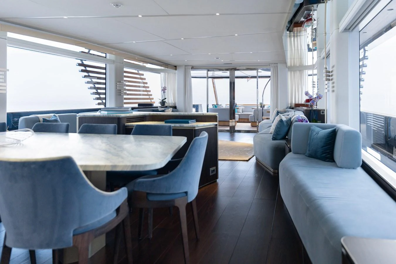 The salon features elegant seating and dining areas with large windows offering panoramic views. aboard PALMAX Yacht for Sale