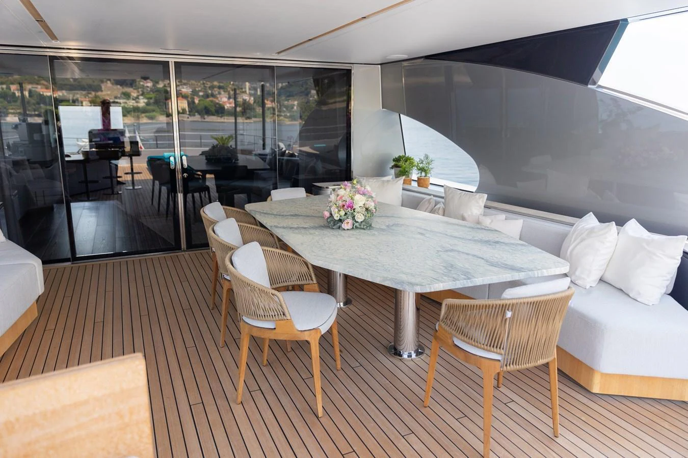 The aft deck features a stylish dining area with a marble table and comfortable seating, perfect for al fresco meals. aboard PALMAX Yacht for Sale