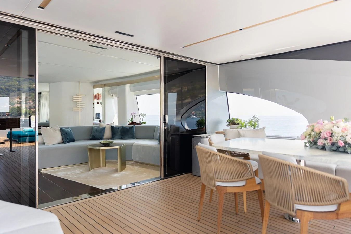 The spacious salon features elegant seating and a dining area with a view. aboard PALMAX Yacht for Sale