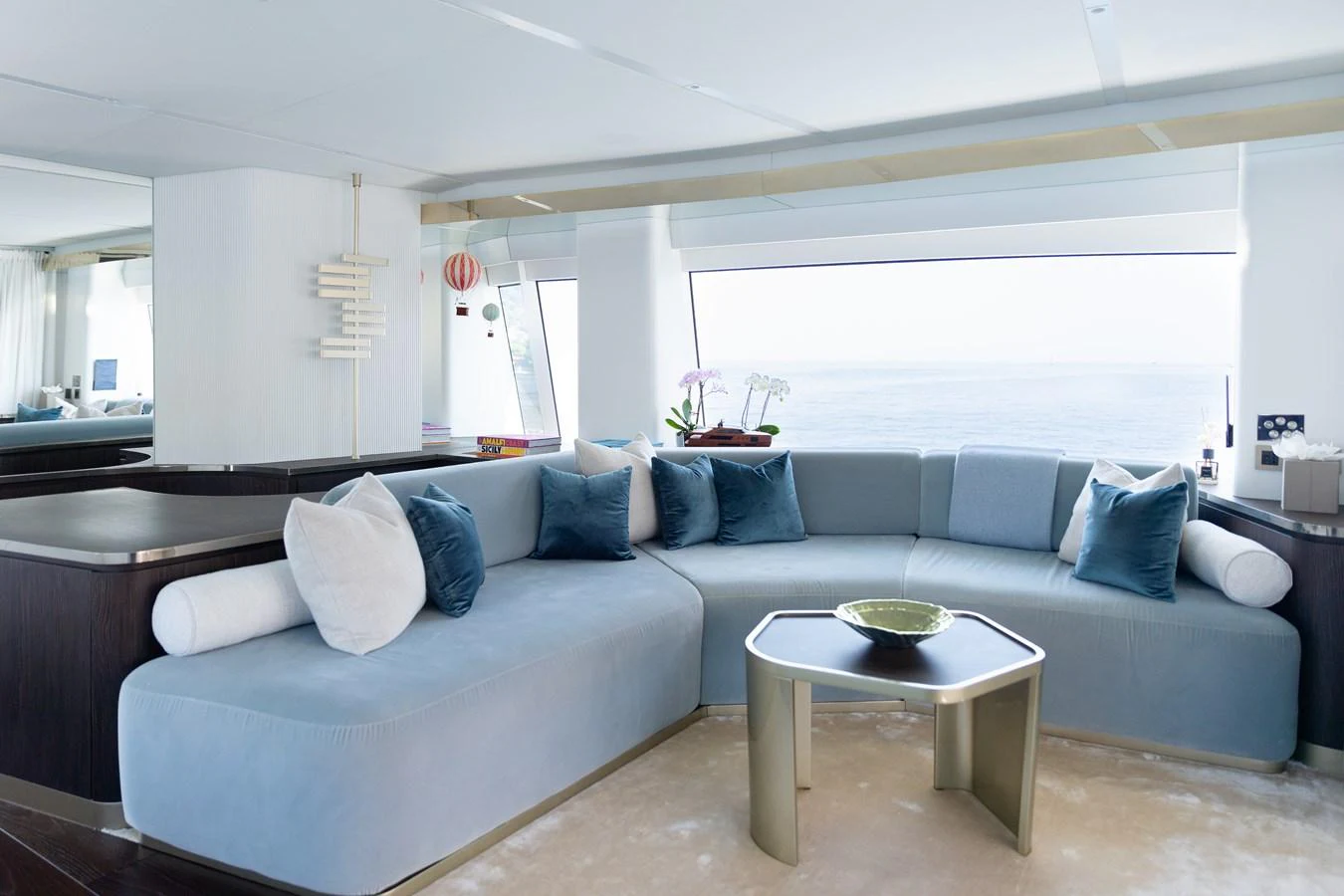 The salon features a spacious and elegantly designed seating area with large windows offering stunning ocean views. aboard PALMAX Yacht for Sale