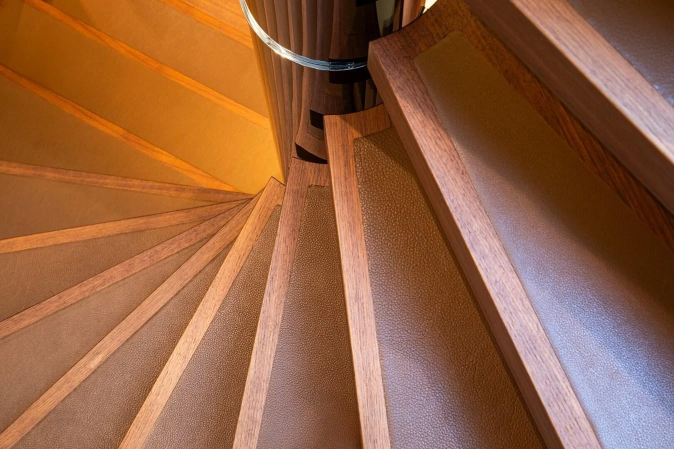 A beautifully crafted spiral staircase with wood and leather detailing. aboard PROMISE Yacht for Sale