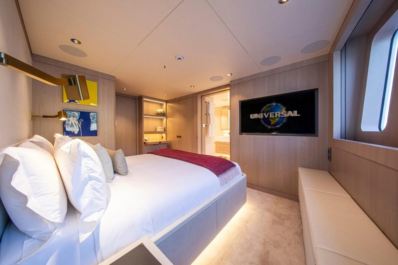 A luxurious stateroom featuring a comfortable bed, modern decor, and a large TV screen. aboard PROMISE Yacht for Sale