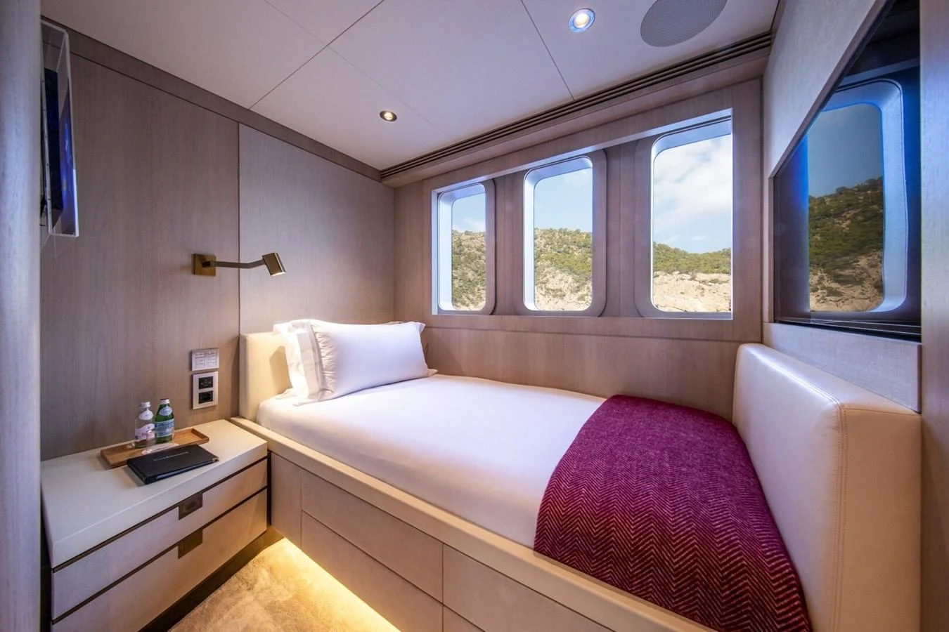 A cozy guest stateroom with a single bed, natural light, and elegant decor. aboard PROMISE Yacht for Sale