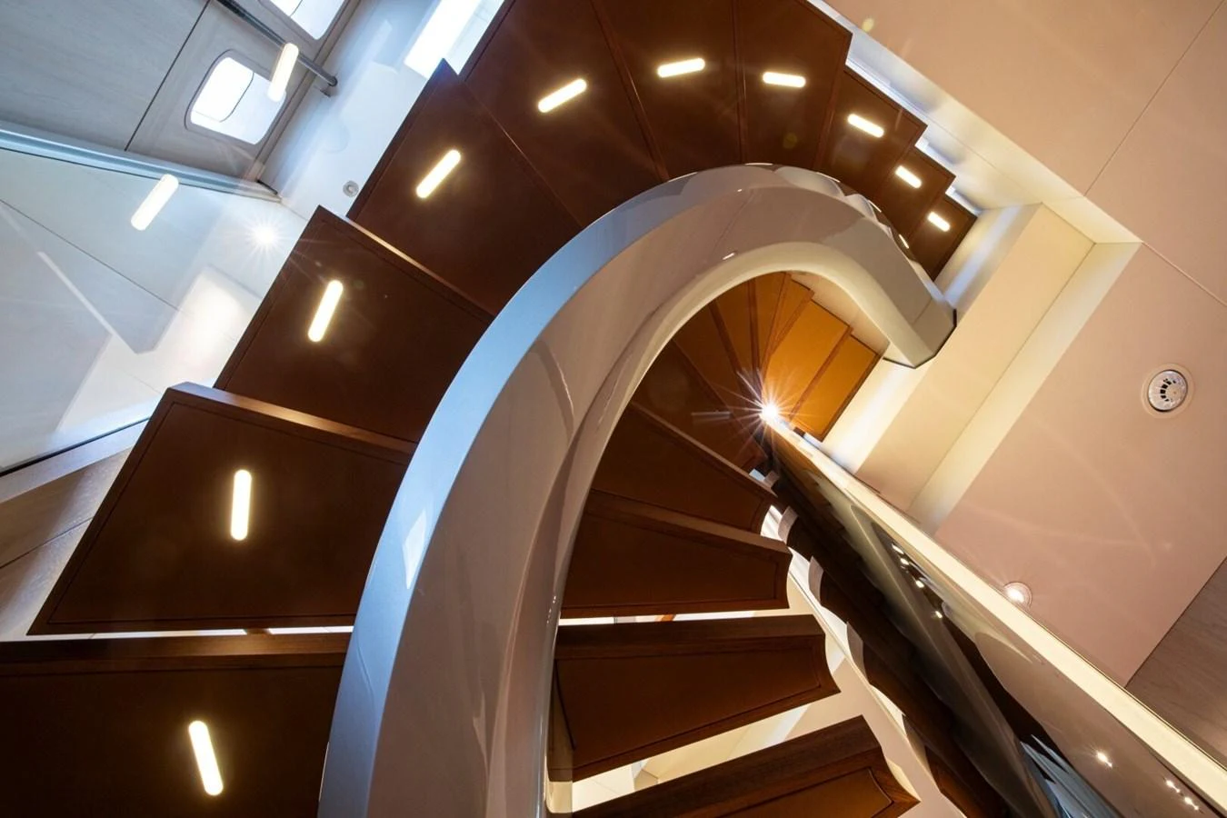 A stunning spiral staircase with modern lighting and sleek design elements. aboard PROMISE Yacht for Sale