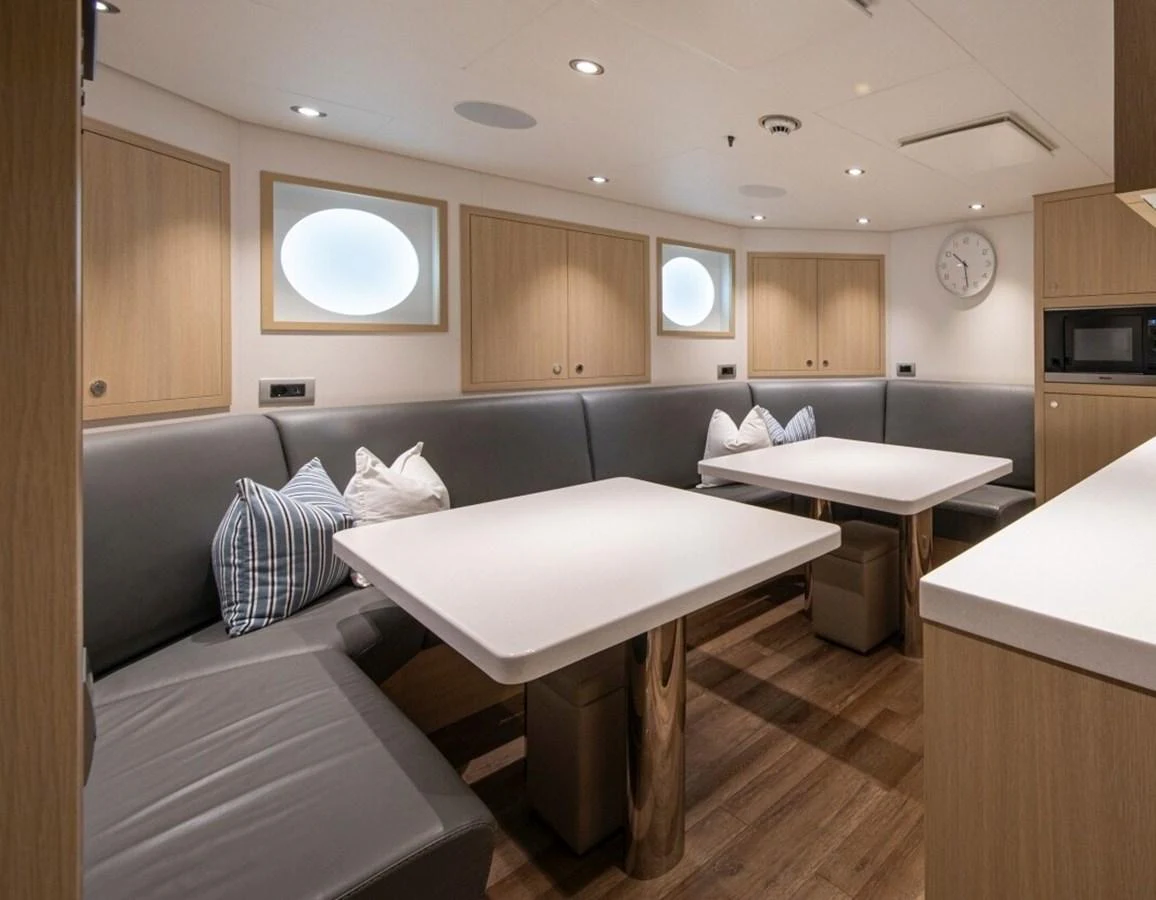 The yacht's dining area features sleek, modern furnishings with ample seating and stylish decor. aboard PROMISE Yacht for Sale