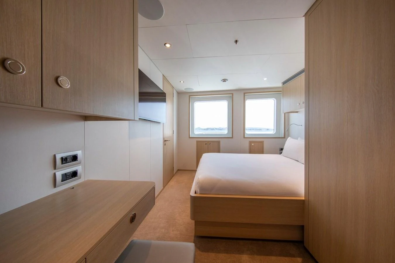 A cozy stateroom with a double bed and ample natural light from two windows. aboard PROMISE Yacht for Sale