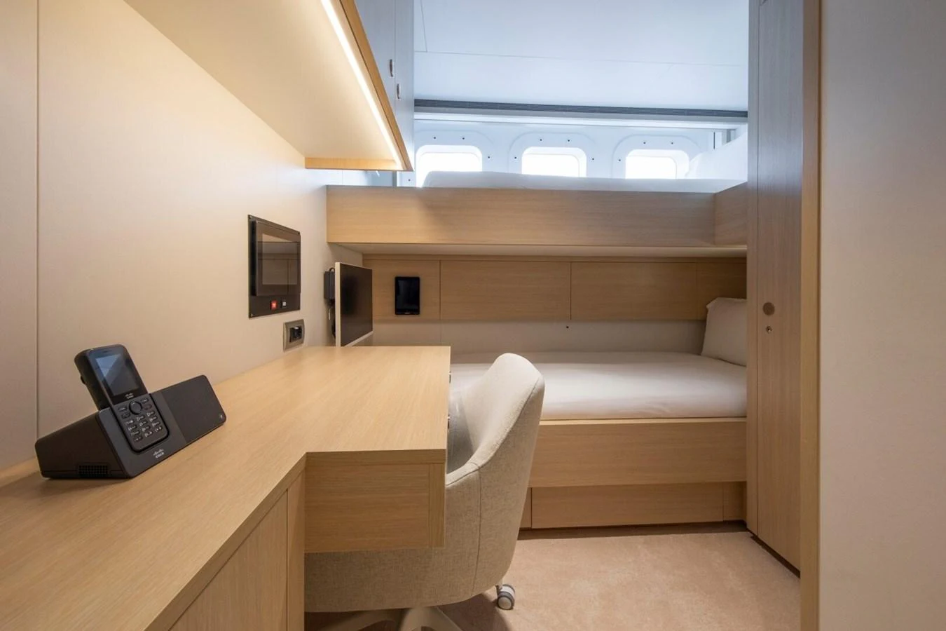 The crew cabin features a compact workspace and a comfortable sleeping area. aboard PROMISE Yacht for Sale