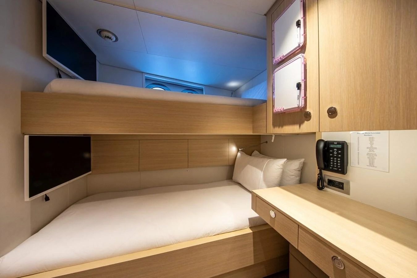 The guest cabin features cozy bunk beds and a functional workspace. aboard PROMISE Yacht for Sale
