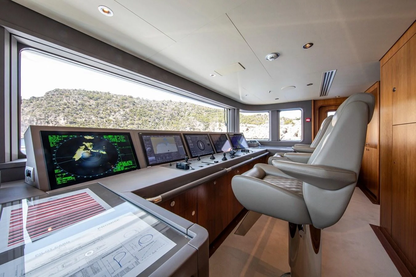 The helm station features advanced navigation equipment and luxurious seating with panoramic views. aboard PROMISE Yacht for Sale