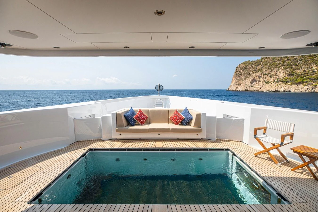 The aft deck features a luxurious seating area and a pristine pool with stunning ocean views. aboard PROMISE Yacht for Sale