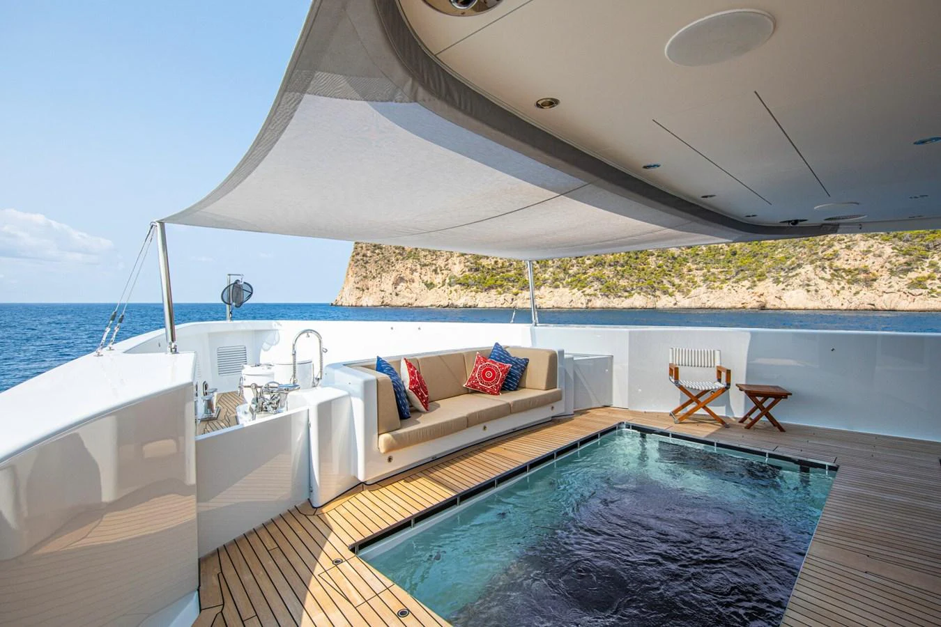 The aft deck features a luxurious seating area and a pool with a stunning ocean view. aboard PROMISE Yacht for Sale