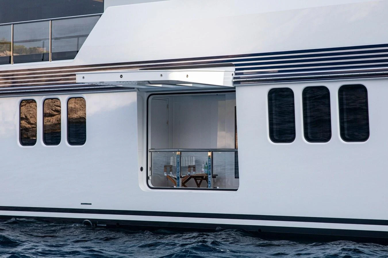 The yacht features a sleek exterior with a fold-out balcony offering a cozy seating area. aboard PROMISE Yacht for Sale