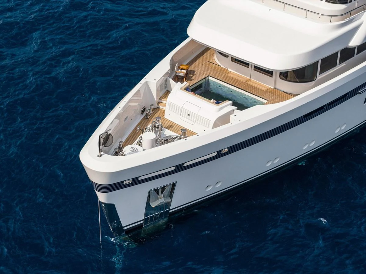 The yacht's foredeck features a luxurious lounging area with a jacuzzi, set against the backdrop of the open sea. aboard PROMISE Yacht for Sale