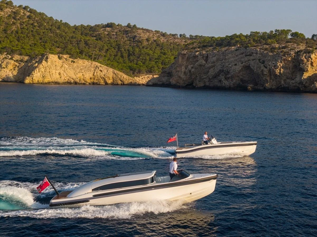 Two sleek tenders cruise side by side in a picturesque coastal setting. aboard PROMISE Yacht for Sale