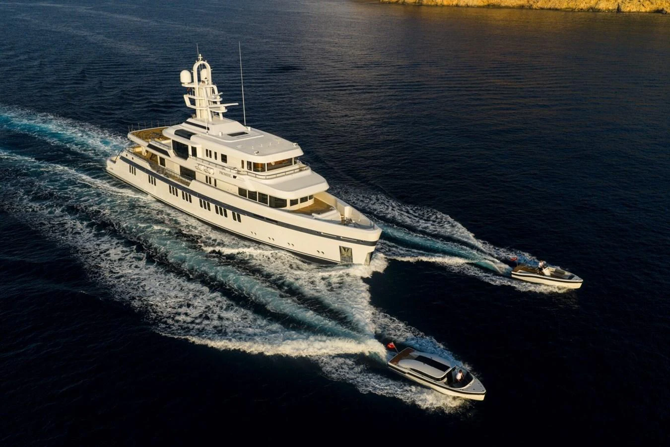 A luxurious yacht cruises through the water accompanied by two sleek tenders. aboard PROMISE Yacht for Sale