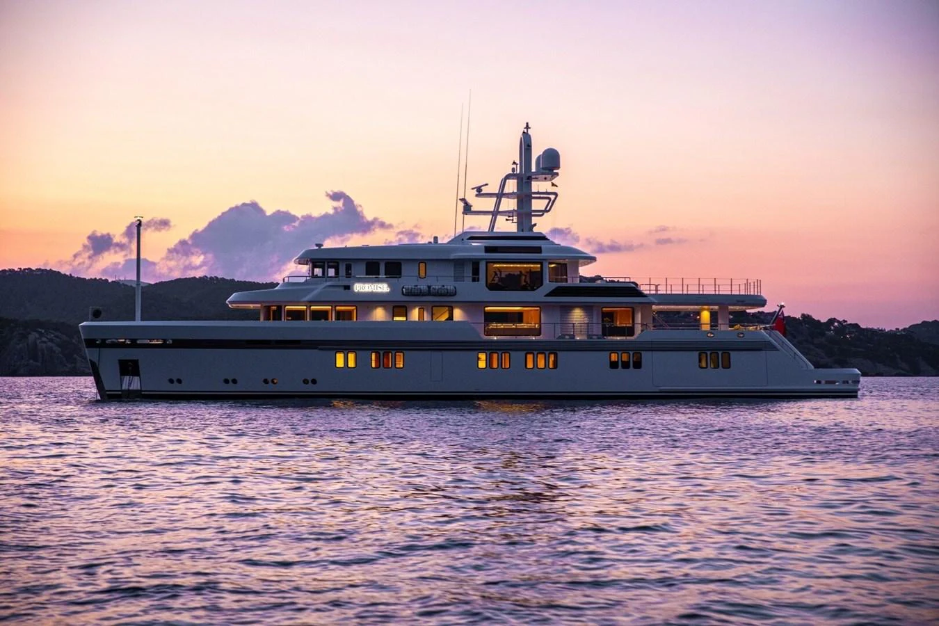 A luxurious yacht is anchored at sunset, showcasing its elegant profile against a serene backdrop. aboard PROMISE Yacht for Sale