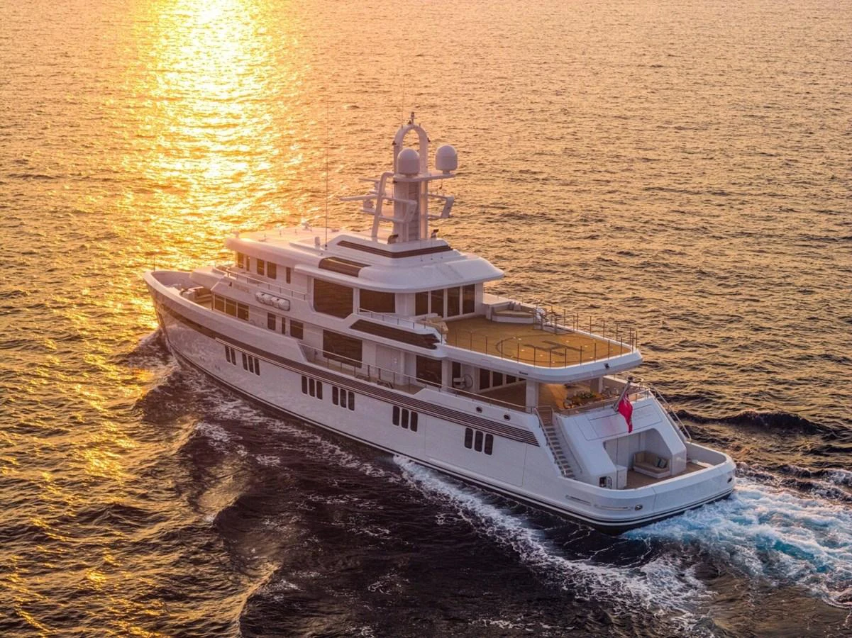 A luxurious yacht cruises through the open sea at sunset, showcasing its elegant design and spacious decks. aboard PROMISE Yacht for Sale