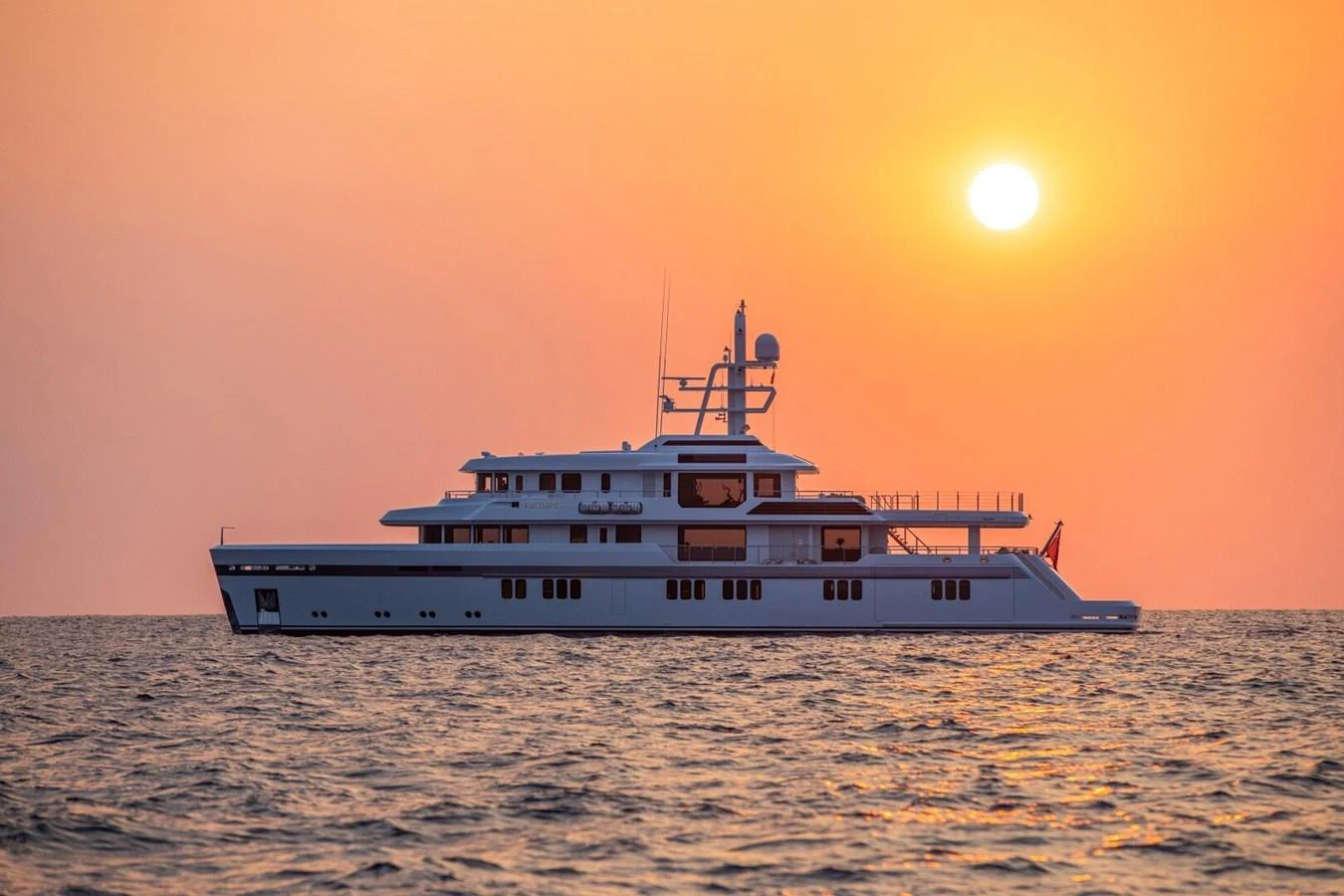 A luxurious yacht sails gracefully on calm waters during a stunning sunset. aboard PROMISE Yacht for Sale