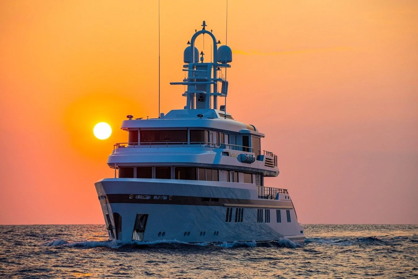 A luxurious yacht sails gracefully on the open sea at sunset. aboard PROMISE Yacht for Sale