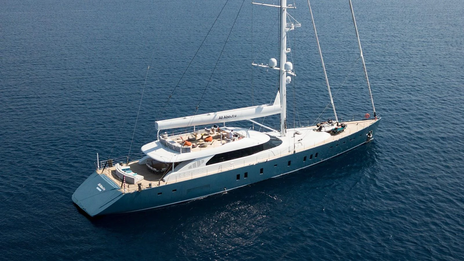A sleek and modern yacht glides gracefully on the open sea, showcasing its elegant design and spacious deck. aboard ALL ABOUT U Yacht for Sale