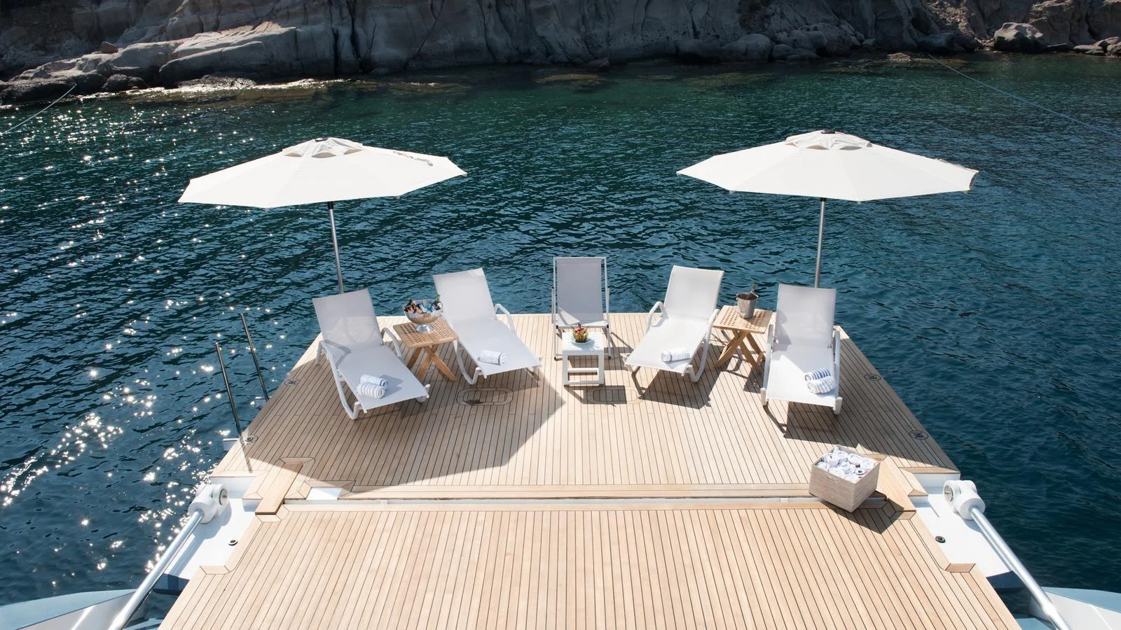 The sundeck offers a serene space with lounge chairs and umbrellas overlooking the water. aboard ALL ABOUT U Yacht for Sale