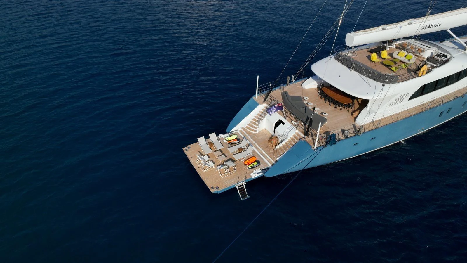 The yacht's aft deck features a spacious lounging area with sunbeds and easy access to the water. aboard ALL ABOUT U Yacht for Sale