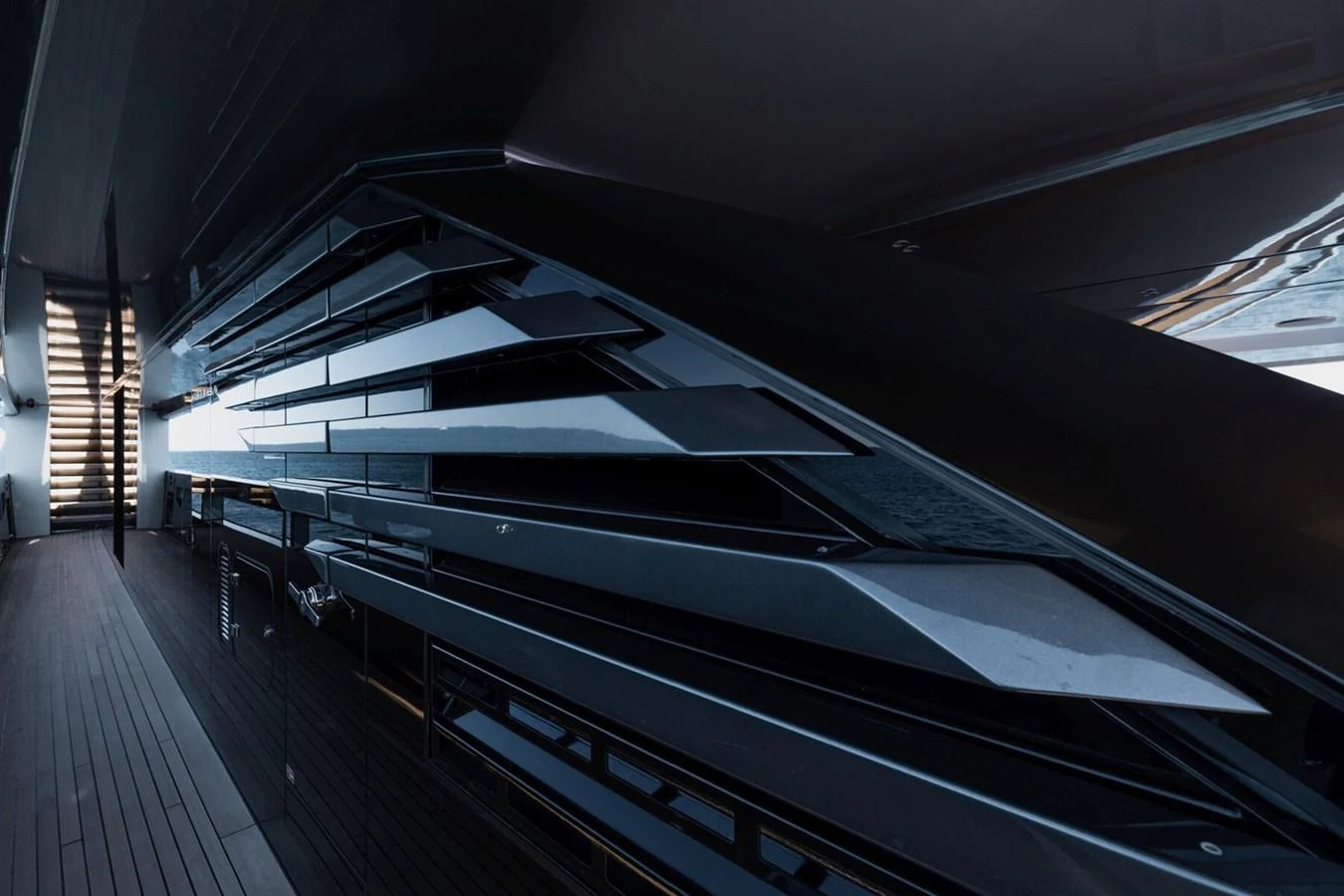 A close-up view of the sleek, modern exterior design of a yacht, showcasing its angular lines and dark finishes. aboard FLYING DAGGER III Yacht for Sale