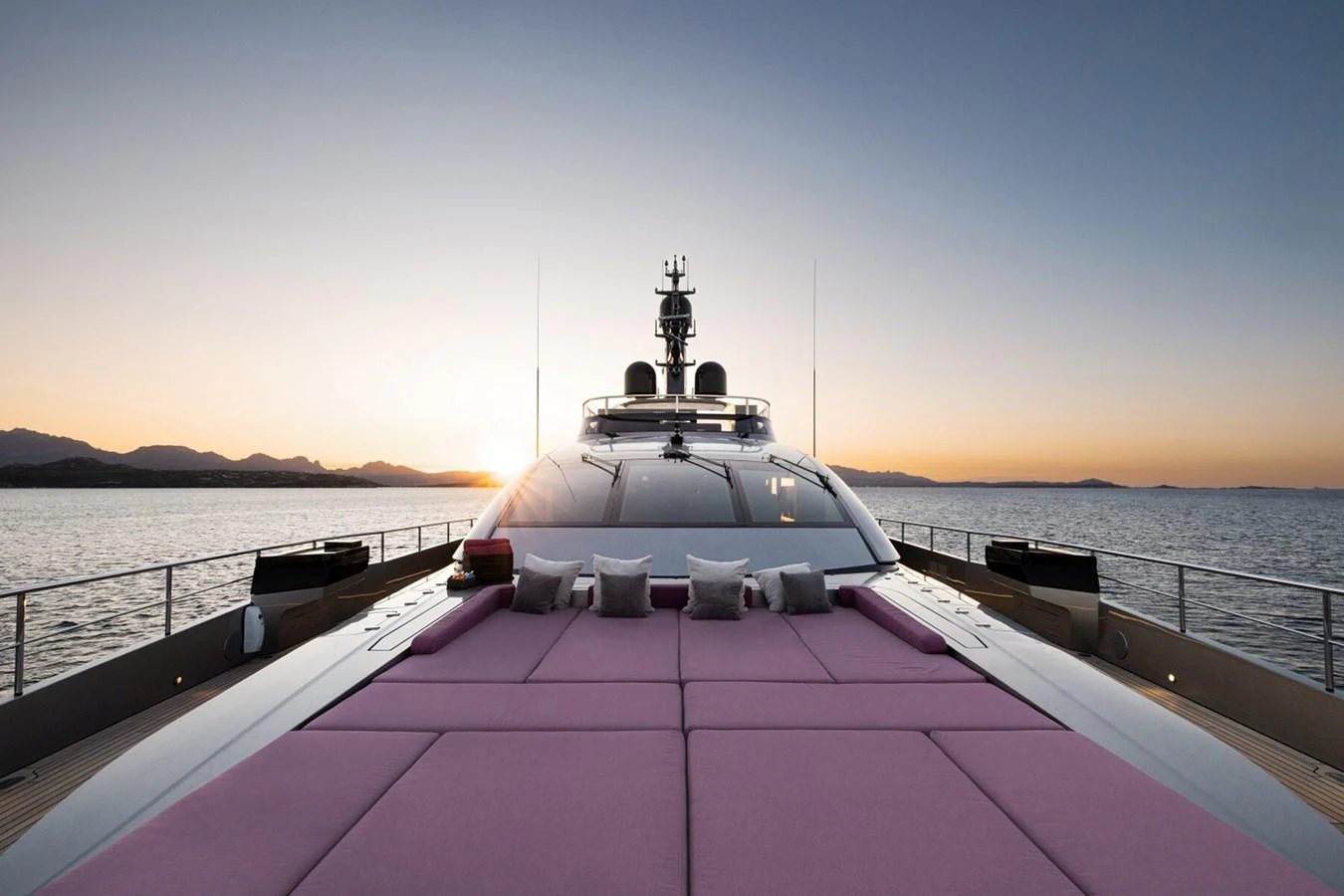 The yacht's foredeck features luxurious sun pads with a stunning sunset view over the water. aboard FLYING DAGGER III Yacht for Sale