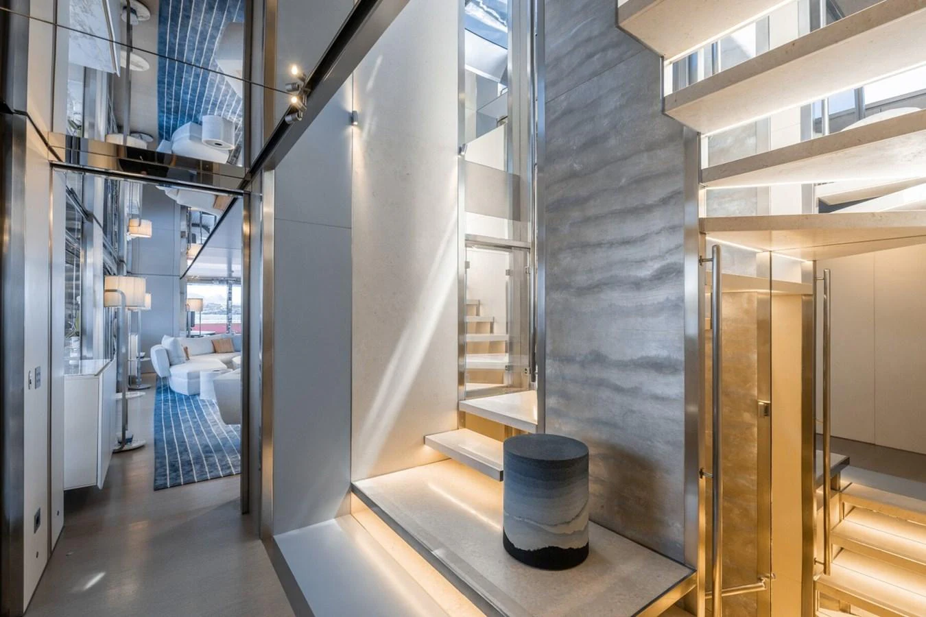 The yacht's interior features a modern staircase with sleek design elements and ambient lighting. aboard FLYING DAGGER III Yacht for Sale