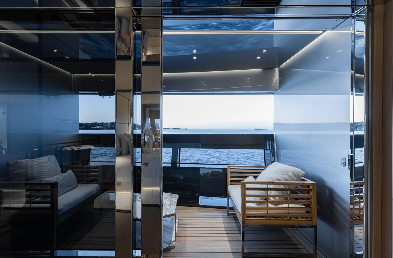 The yacht's salon features modern furnishings with a serene view of the sea through large windows. aboard FLYING DAGGER III Yacht for Sale