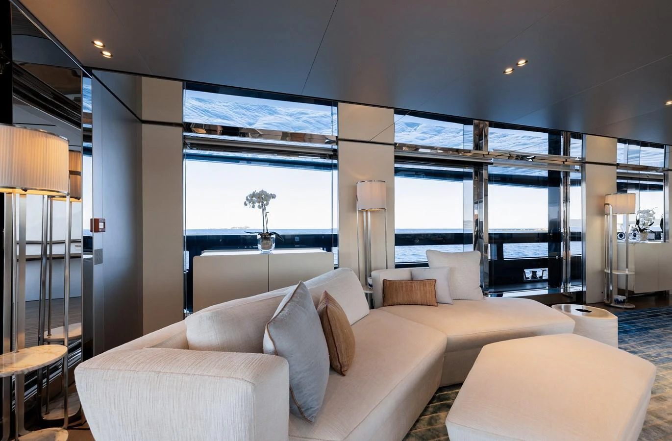 The yacht's interior features a luxurious and spacious lounge area with modern furnishings and large windows offering stunning sea views. aboard FLYING DAGGER III Yacht for Sale
