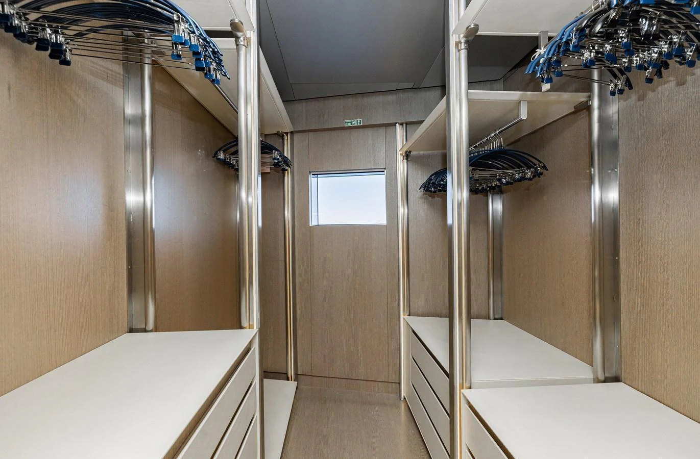 This spacious walk-in closet features ample storage with sleek wooden finishes and modern fixtures. aboard FLYING DAGGER III Yacht for Sale