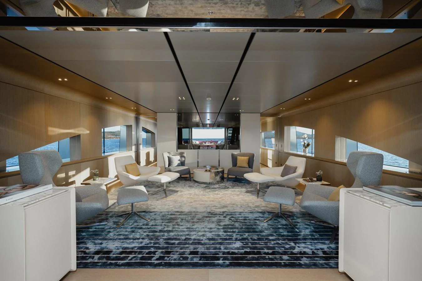 The salon features modern furnishings with ample natural light and panoramic views. aboard FLYING DAGGER III Yacht for Sale