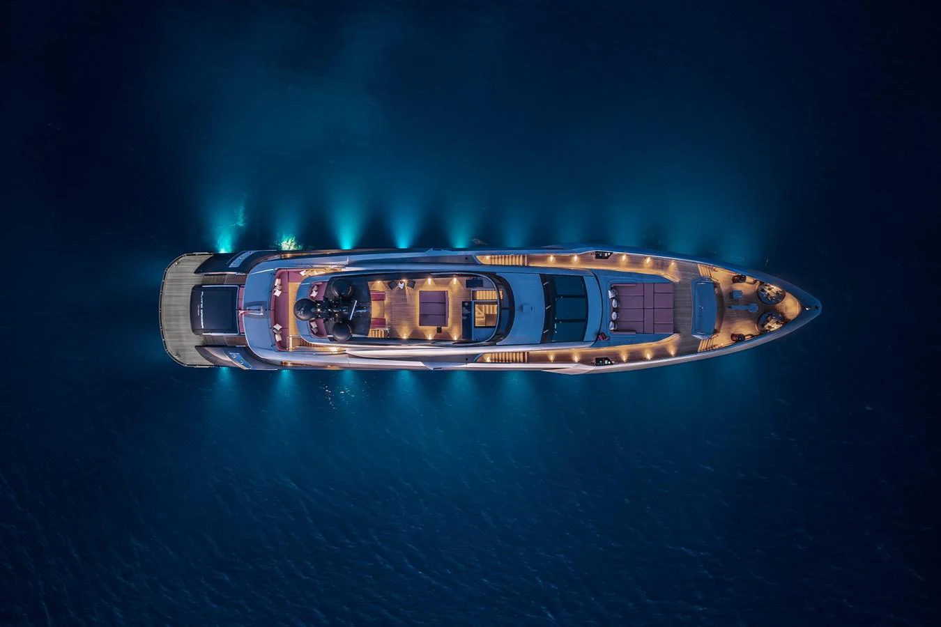 A stunning aerial view of a yacht illuminated at night, showcasing its elegant design and ambient lighting. aboard FLYING DAGGER III Yacht for Sale