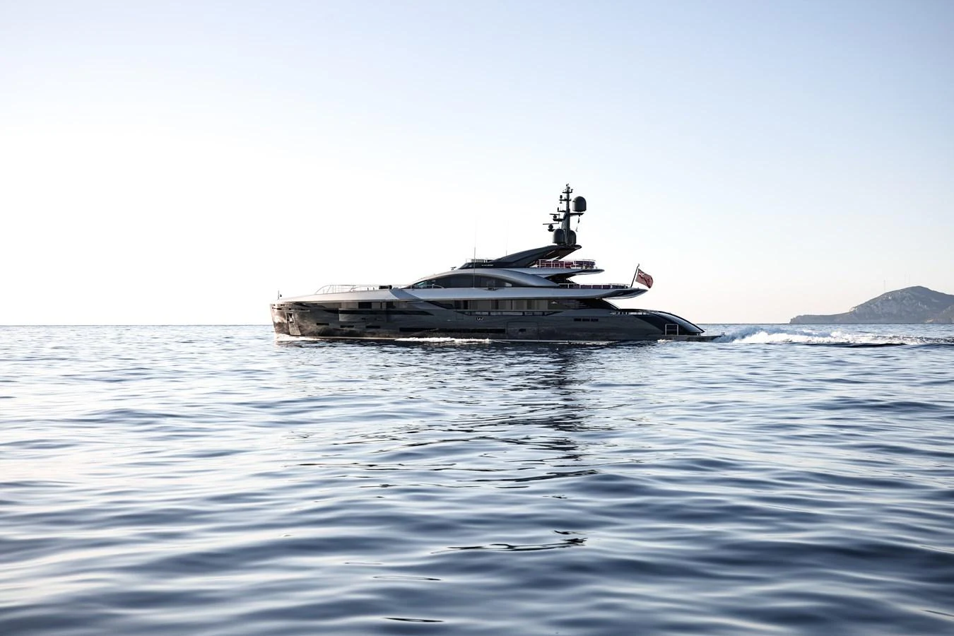 A sleek and modern yacht cruising on calm waters with a scenic backdrop. aboard FLYING DAGGER III Yacht for Sale