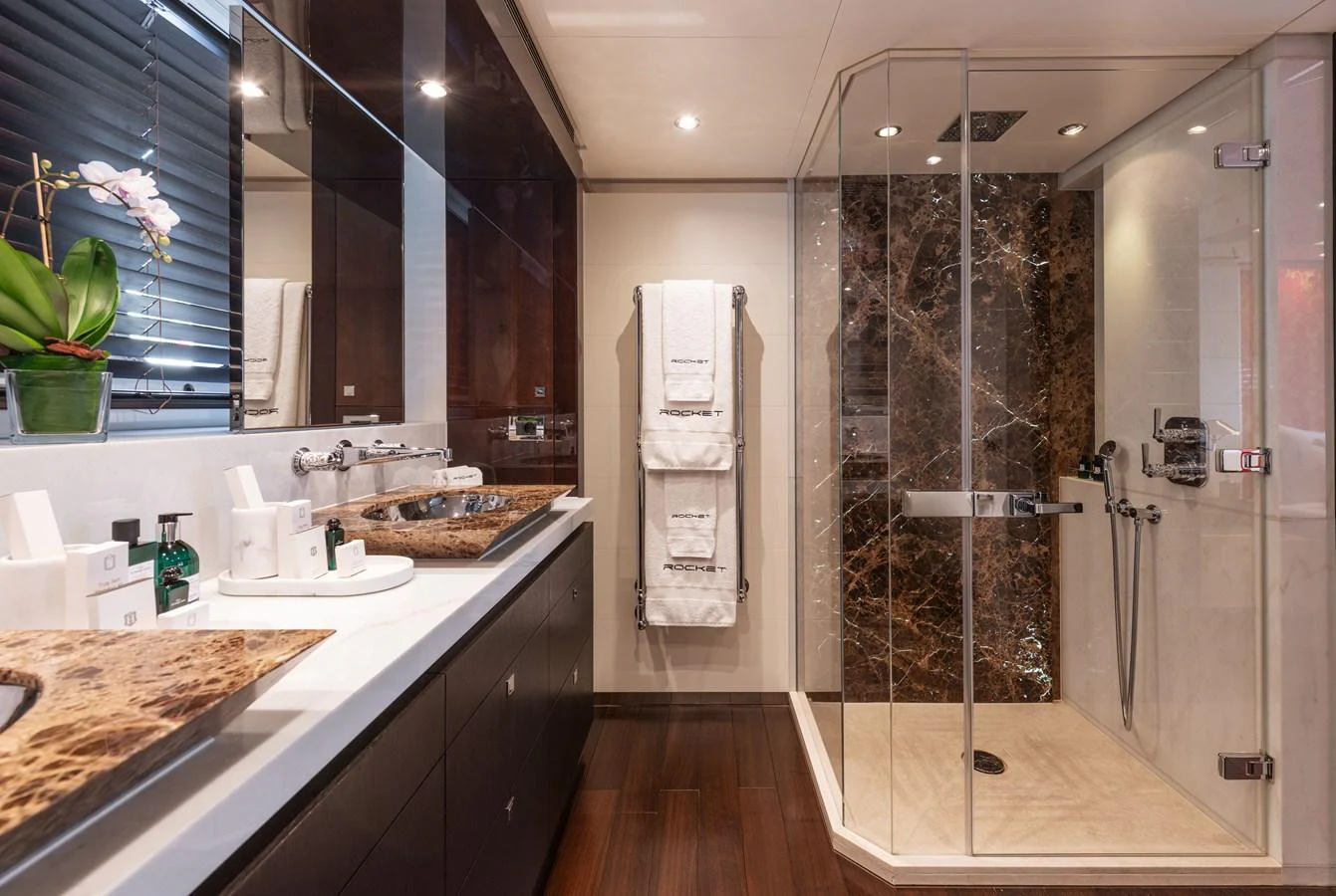 The yacht's bathroom features a luxurious design with a spacious shower and elegant fixtures. aboard ROCKET Yacht for Sale