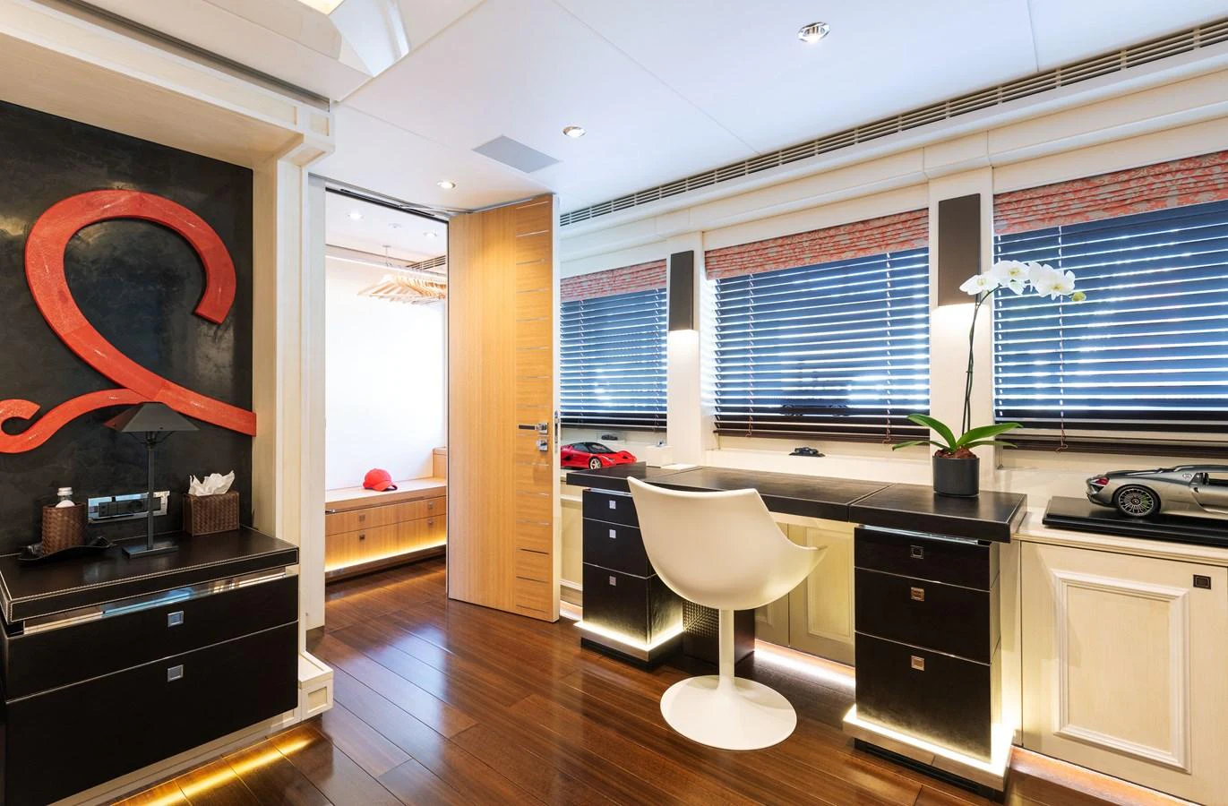 A stylish and modern interior space featuring a desk area with sleek furnishings and decor. aboard ROCKET Yacht for Sale