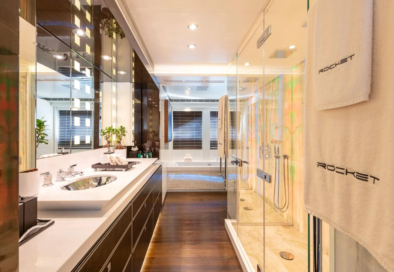 The yacht's bathroom features a luxurious design with a spacious shower and elegant fixtures. aboard ROCKET Yacht for Sale