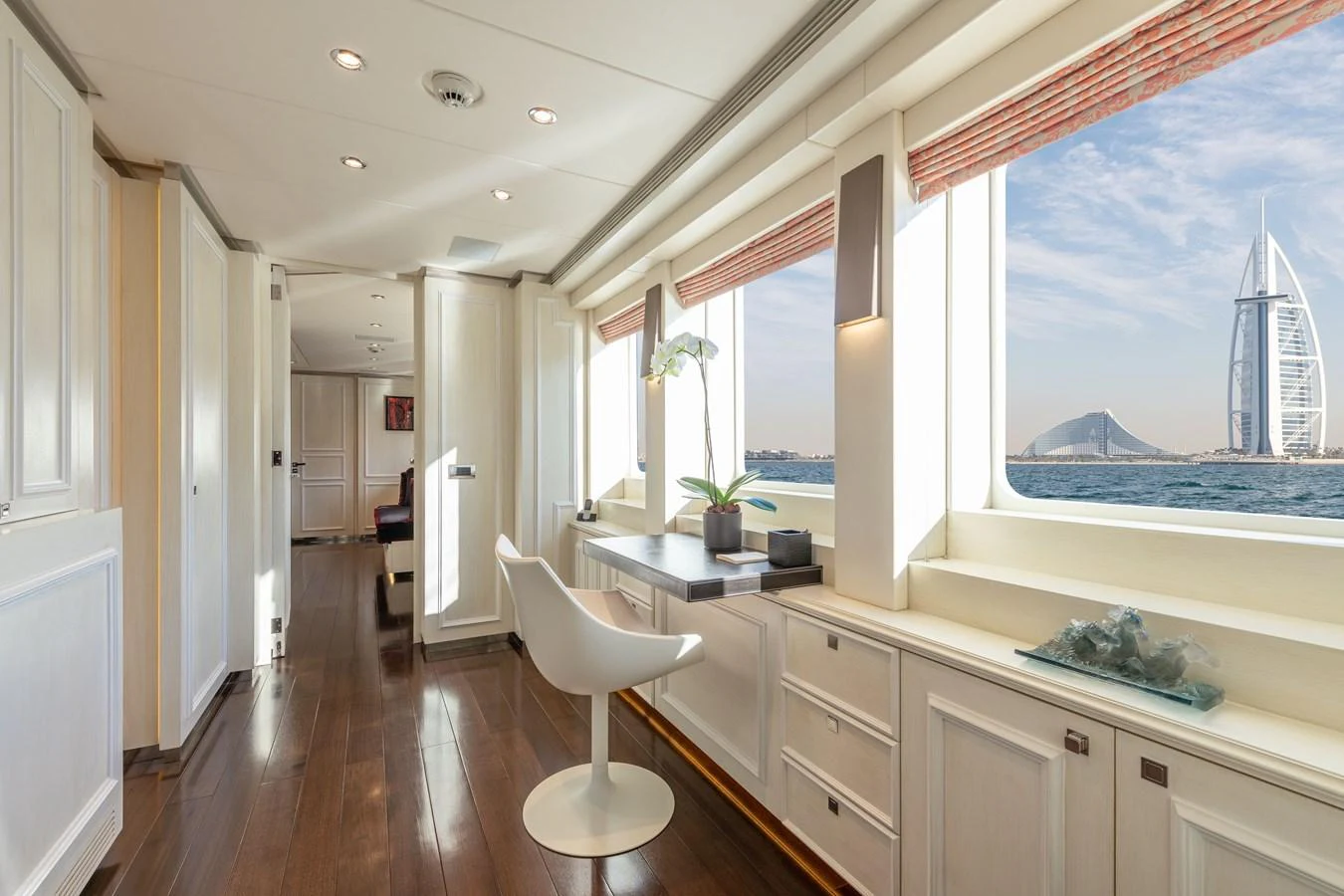 The salon features elegant wood flooring, ample natural light, and a stunning view through large windows. aboard ROCKET Yacht for Sale