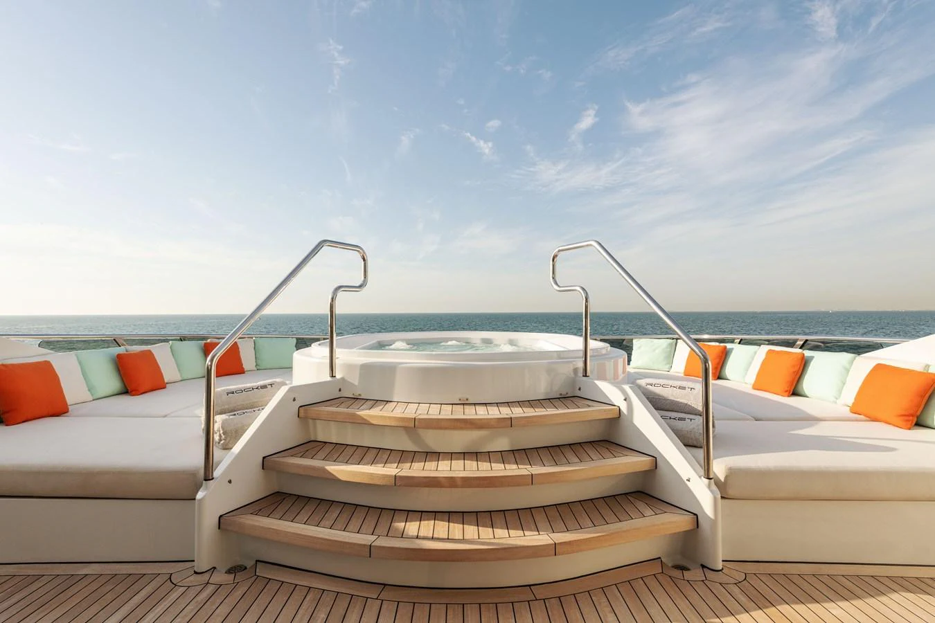The sundeck features a luxurious jacuzzi surrounded by comfortable lounging areas with vibrant cushions. aboard ROCKET Yacht for Sale
