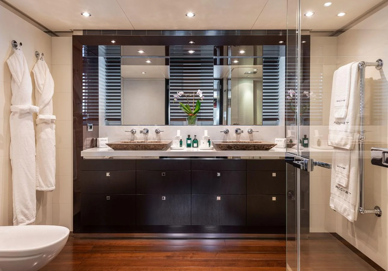 The yacht's bathroom features a luxurious double sink vanity with elegant fixtures and modern design. aboard ROCKET Yacht for Sale