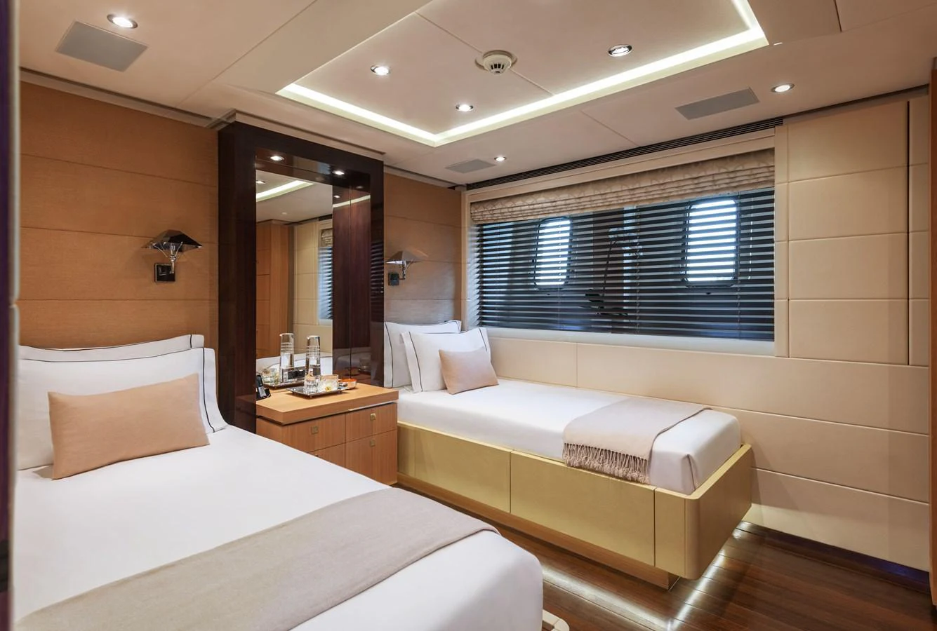 The guest stateroom offers a cozy and elegant retreat with twin beds and modern amenities. aboard ROCKET Yacht for Sale