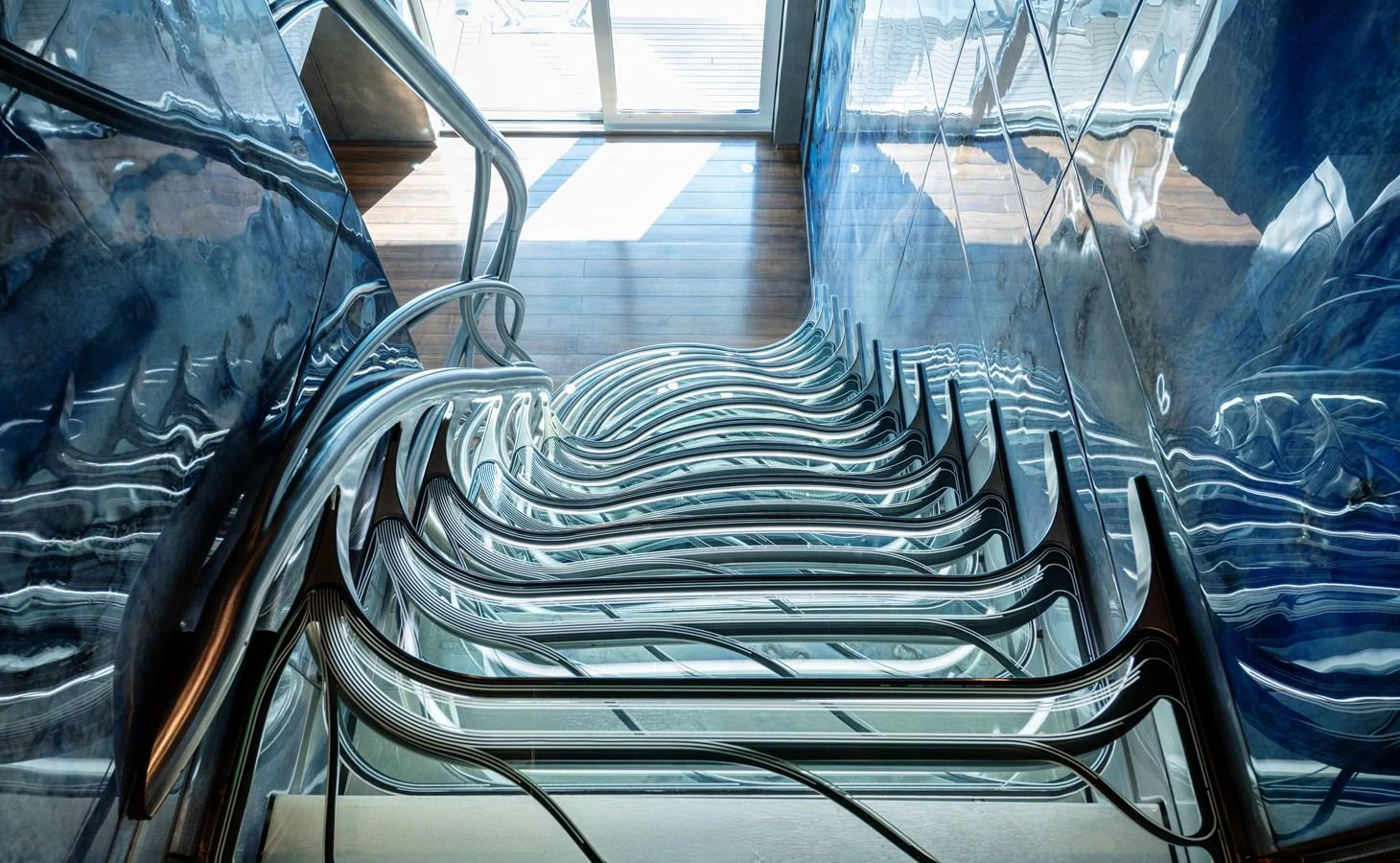 A stunningly designed staircase with sleek, modern lines and reflective surfaces. aboard ROCKET Yacht for Sale