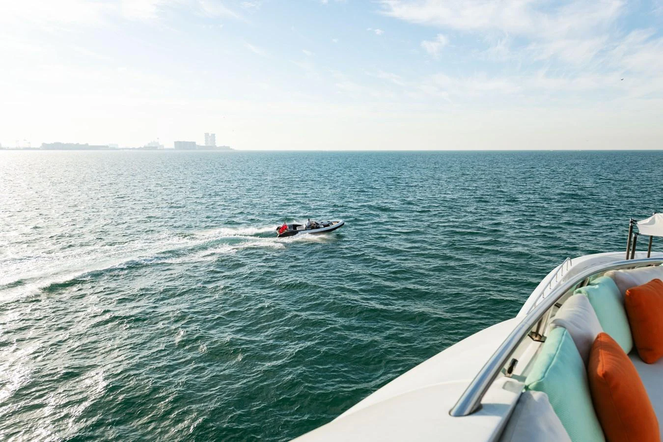 A view from the yacht showing the ocean and a small boat speeding by. aboard ROCKET Yacht for Sale