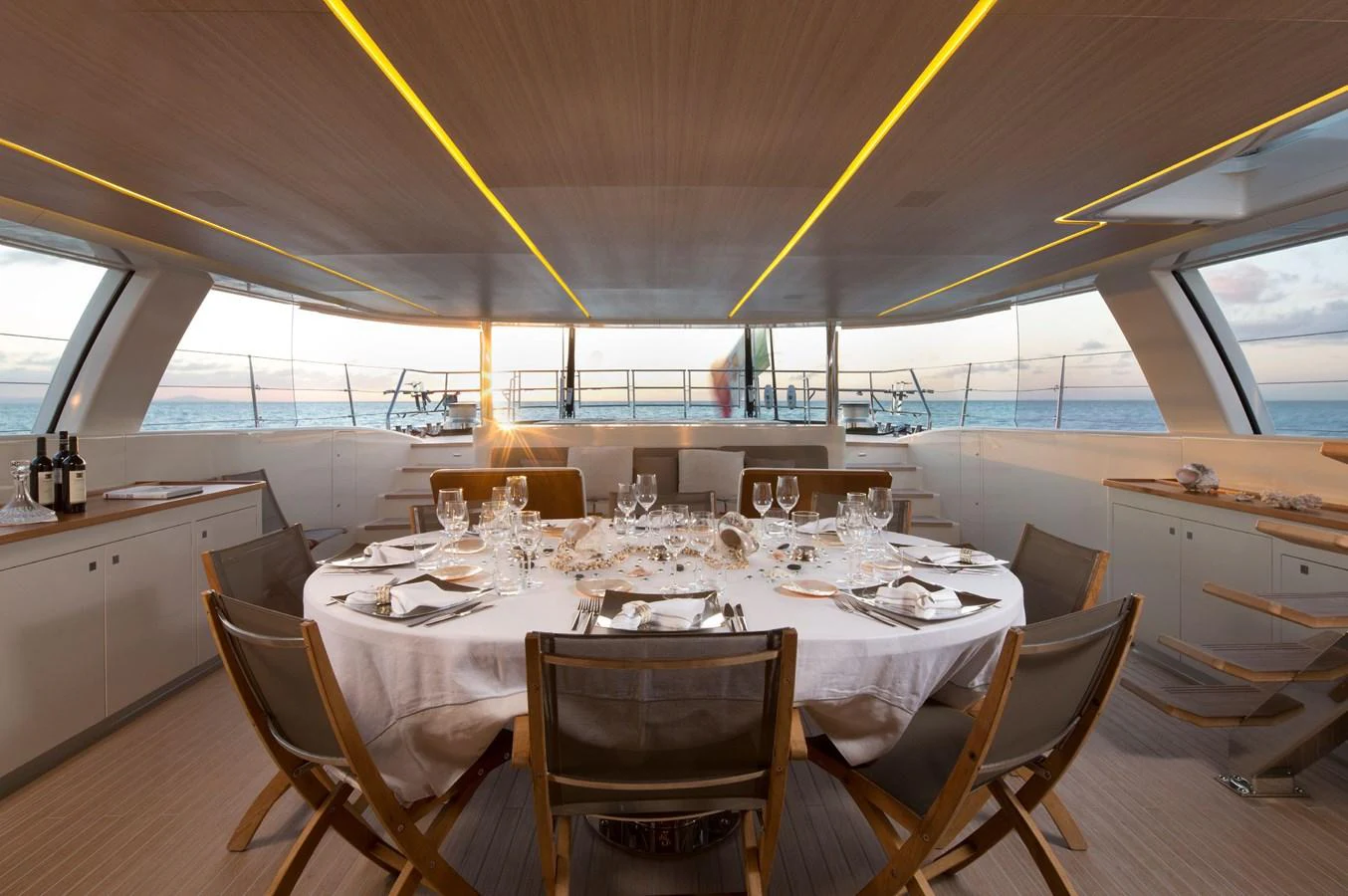 The yacht's dining area offers a luxurious setting with panoramic ocean views and elegant table settings. aboard OHANA Yacht for Sale