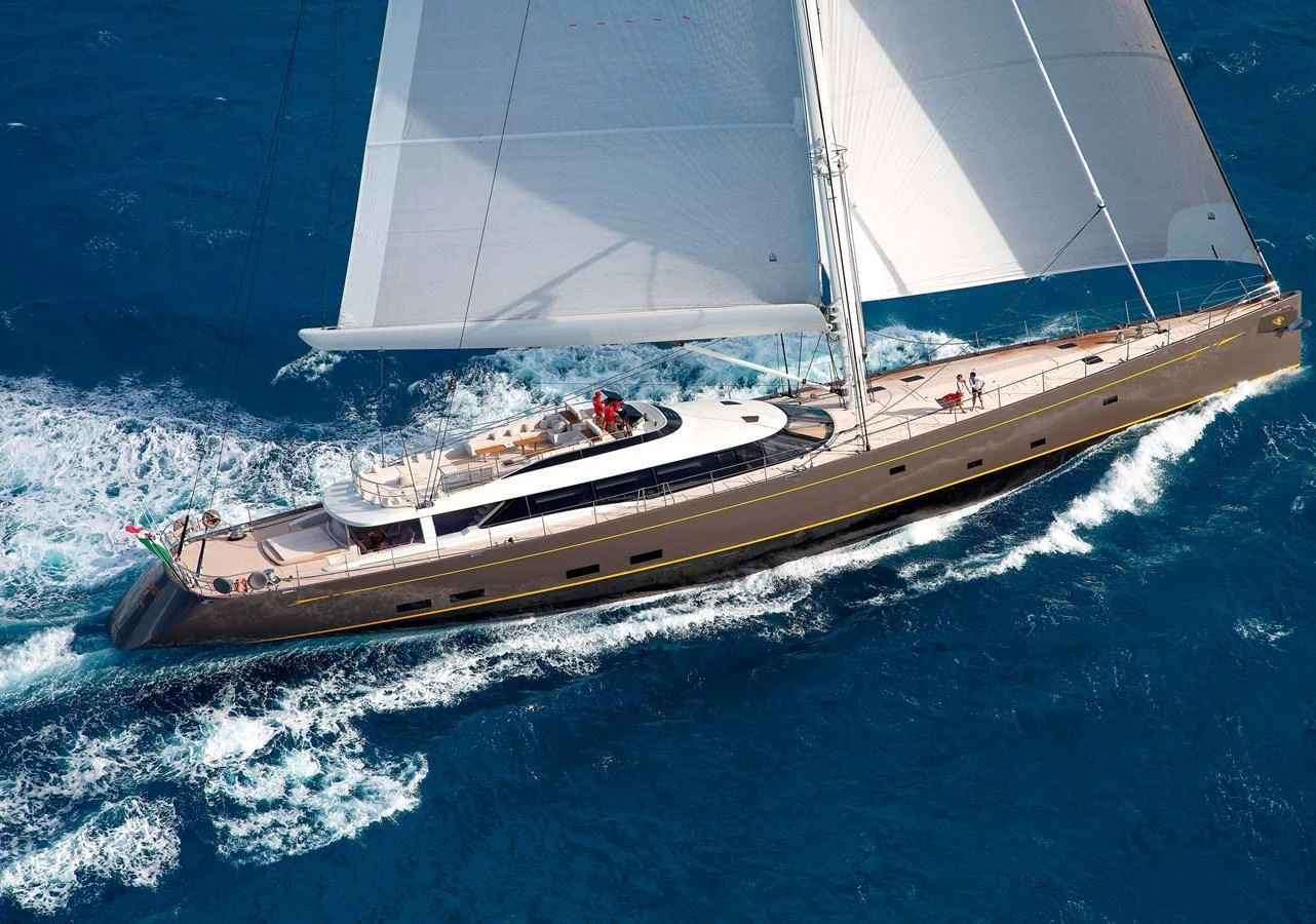 A sleek sailing yacht glides gracefully through the vibrant blue waters. aboard OHANA Yacht for Sale