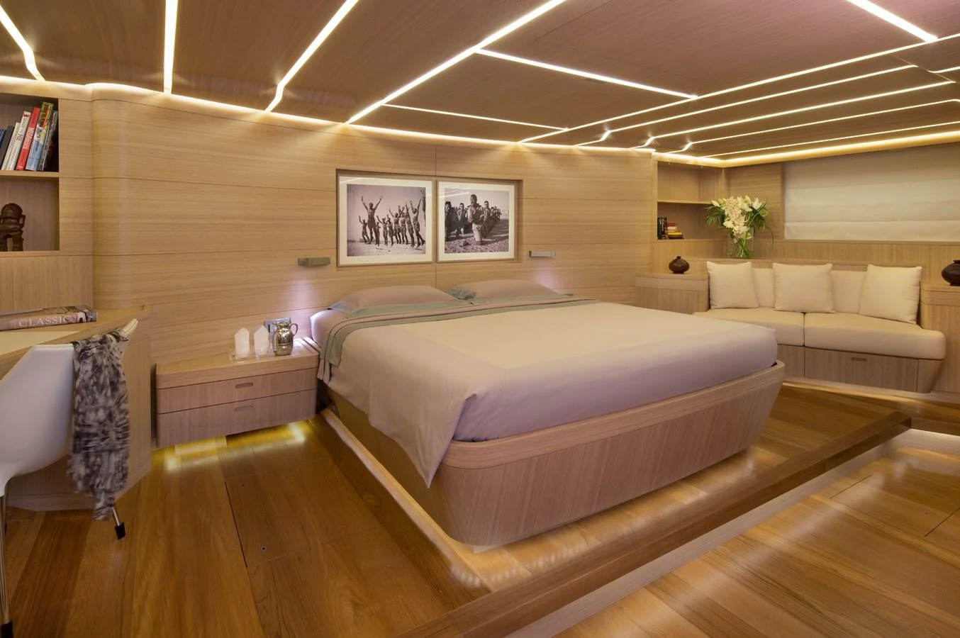 The master stateroom features a spacious bed, elegant lighting, and luxurious wooden finishes. aboard OHANA Yacht for Sale
