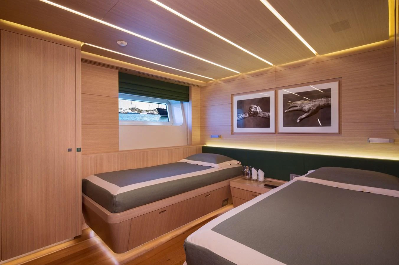 The guest stateroom features twin beds with modern decor and ample natural light. aboard OHANA Yacht for Sale