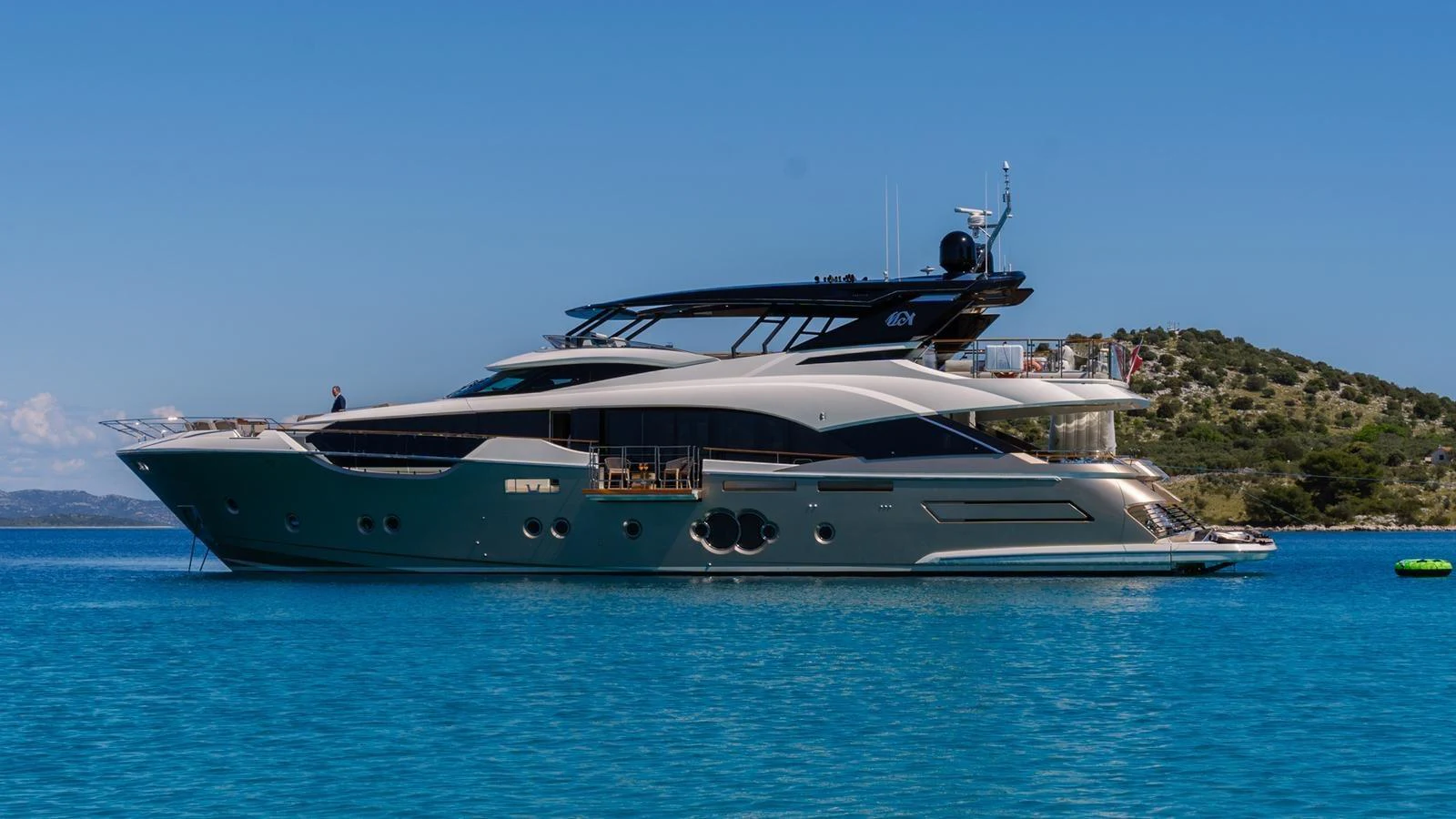 A sleek and modern yacht is anchored in clear blue waters, showcasing its elegant design and luxurious amenities. aboard VIVALDI Yacht for Sale