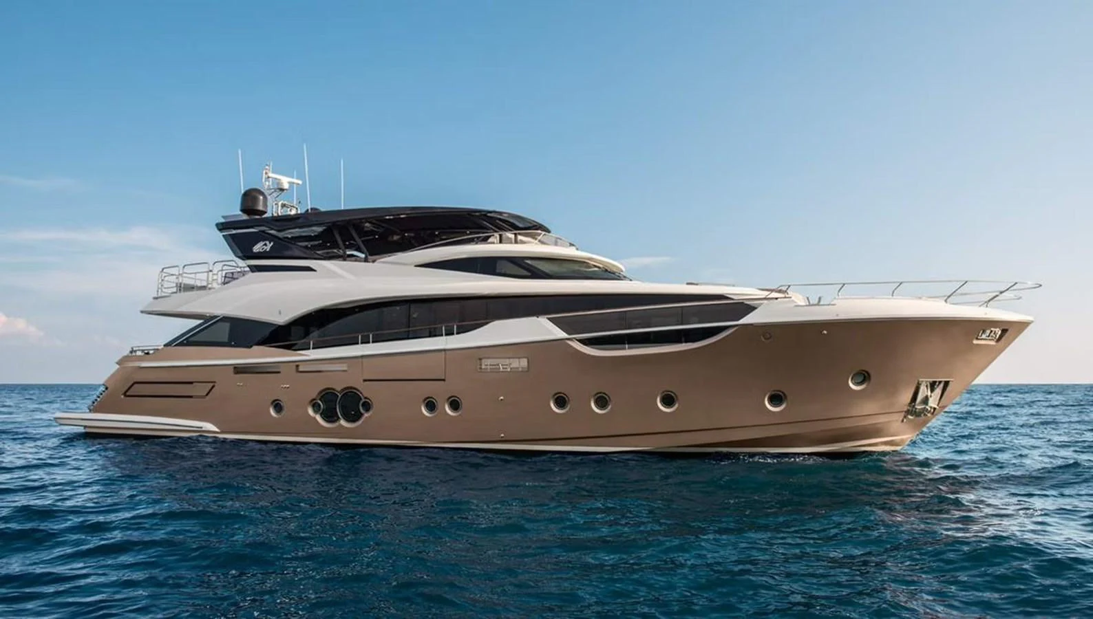A luxurious yacht cruising on calm blue waters under a clear sky. aboard VIVALDI Yacht for Sale